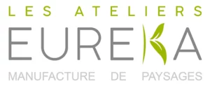 Image d'un logo montrant le texte Les Ateliers EUREKA Manufacture de Paysages. Le mot EUREKA est écrit en grandes lettres grises avec une feuille verte stylisée intégrée dans la lettre K. Le reste du texte est en vert et gris.